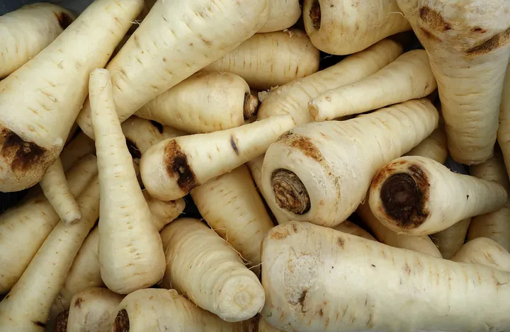 A pile of fresh parsnips at a market stall